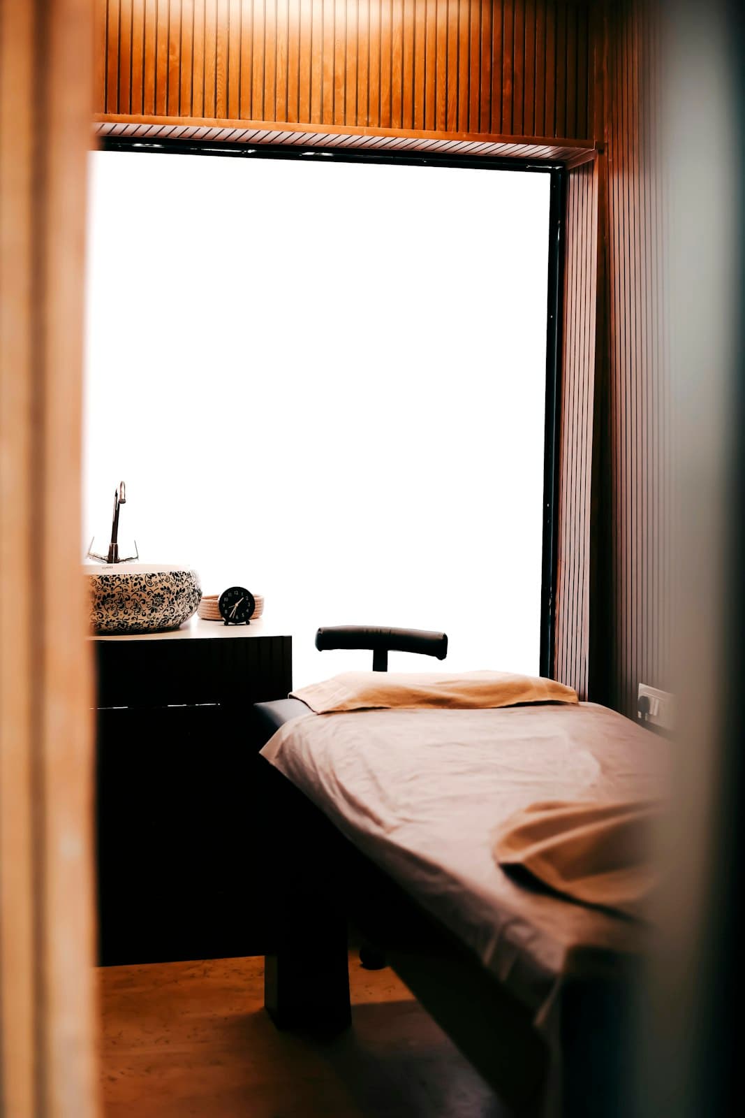 Phòng trị liệu nhỏ có giường đơn và cửa sổ lớn
